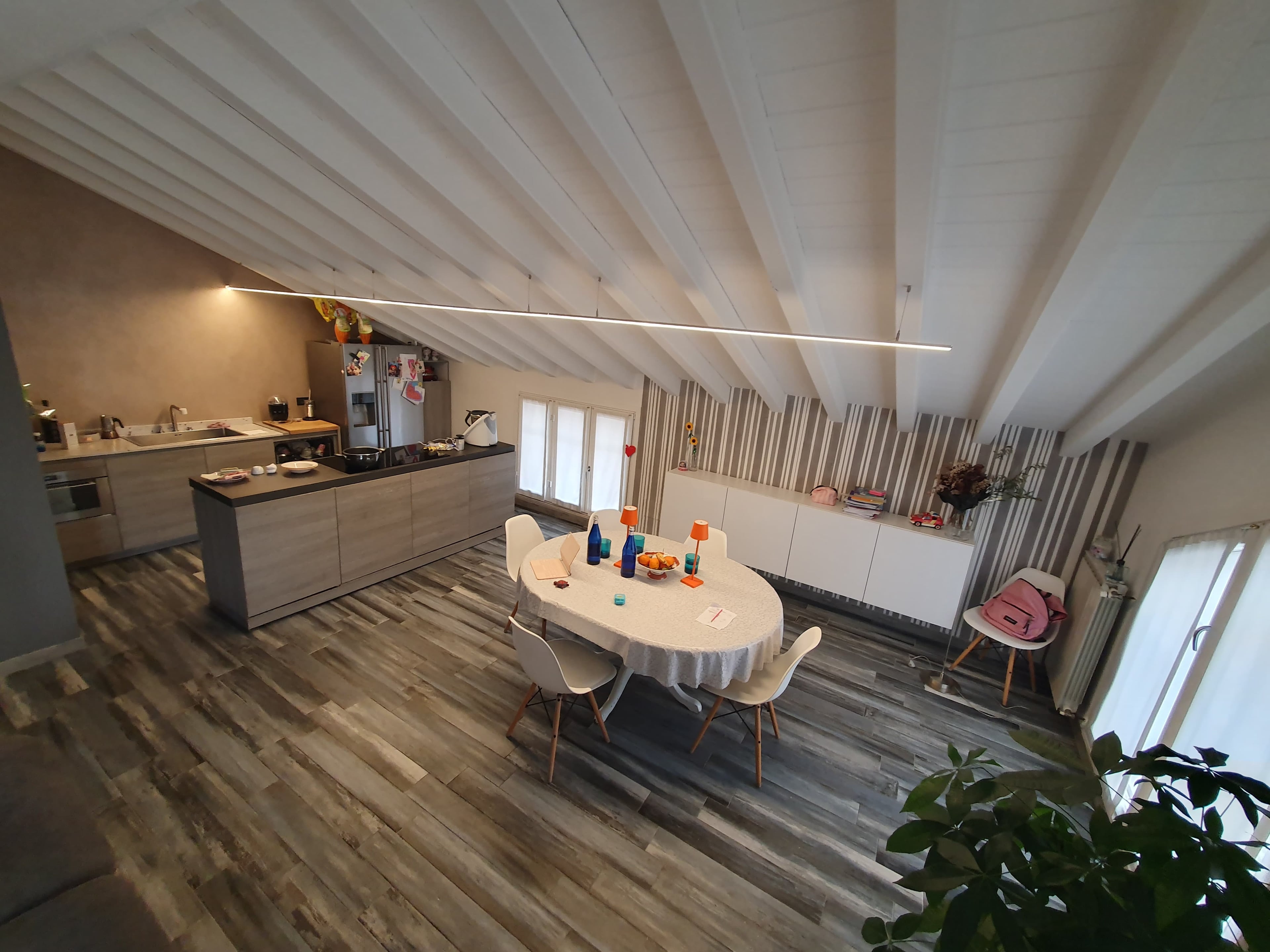 Vista dell'open space mansardato con sospensione lineare LED che attraversa tutta la stanza